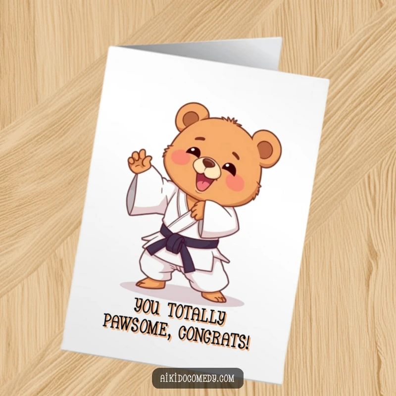 Funny Free Printable Congratulations Card showing a happy bear cub in a gi, striking a triumphant and playful Aikido pose.