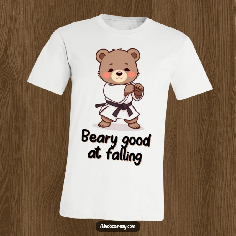 Funny t-shirt showcasing a determined bear cub in a martial arts uniform executing a gentle Aikido roll with adorable focus.
